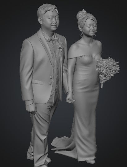 Gray-scale sculpture of a couple in formal attire against a dark background