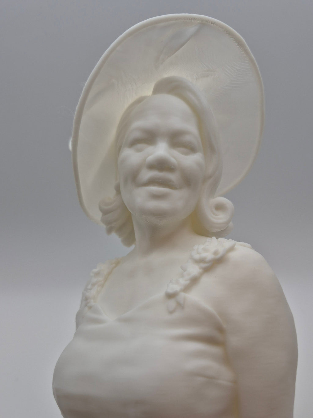 White ceramic bust of a woman on a plain background